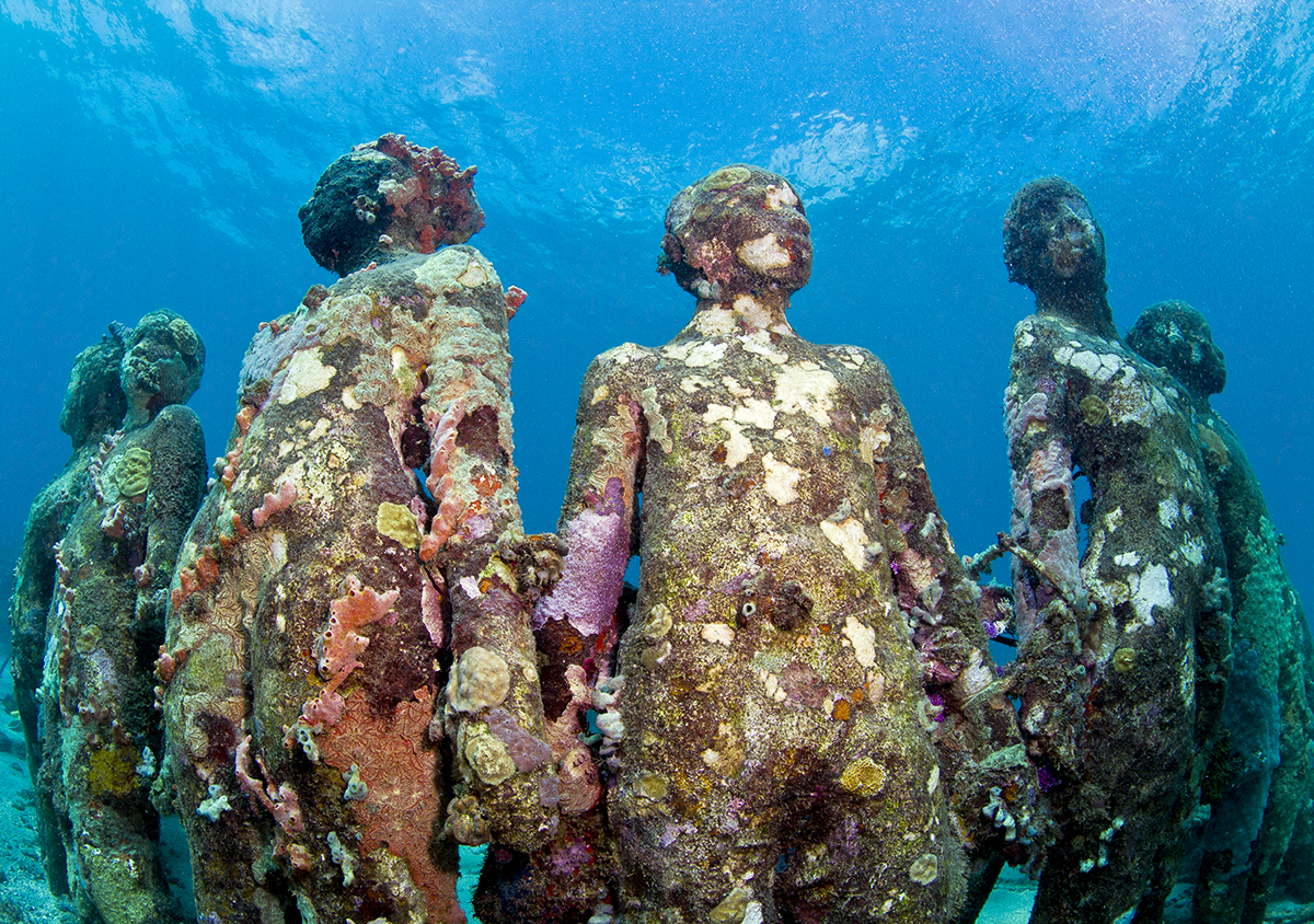 Underwater sculptures covered in coral