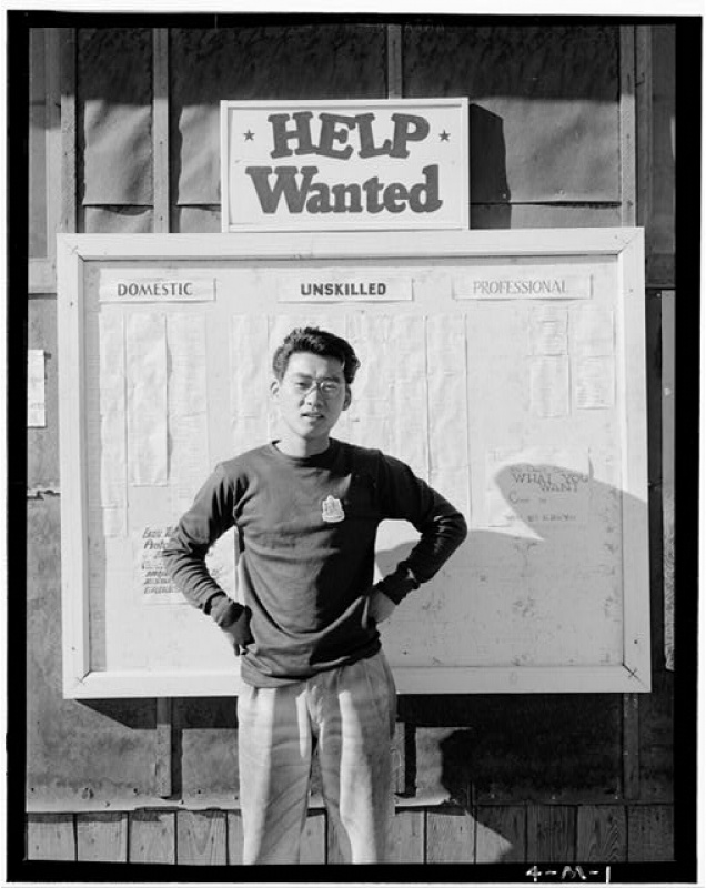 Man standing in front of help wanted sign