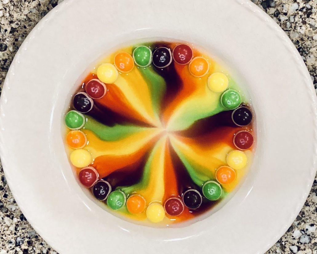 Color melting off skittles on a plate