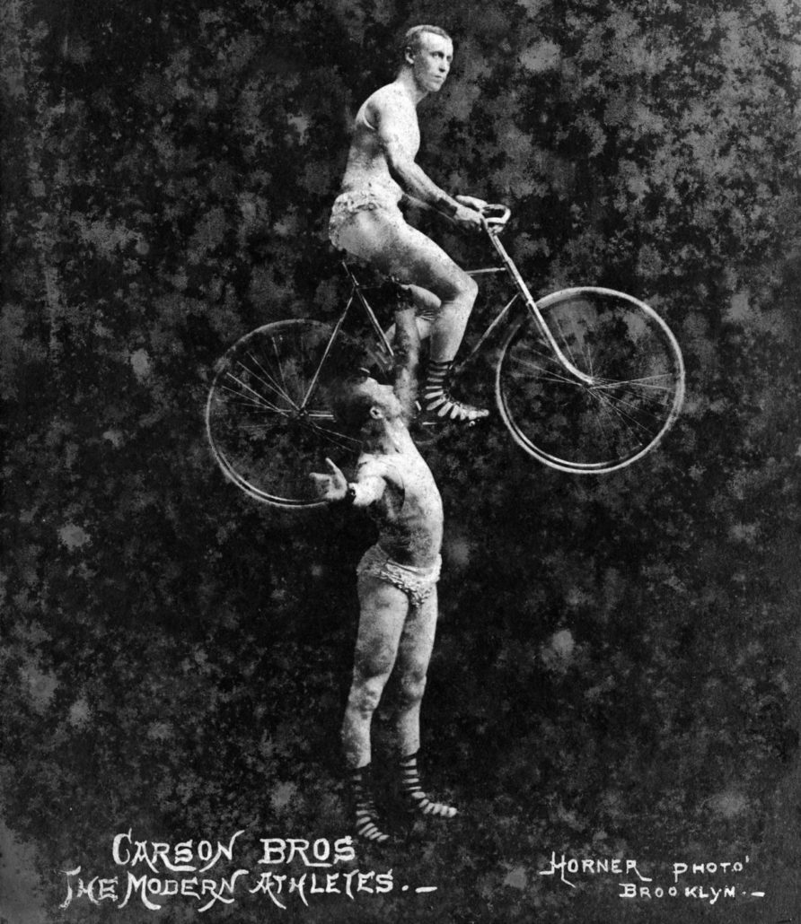 Man holding another man riding a bicycle