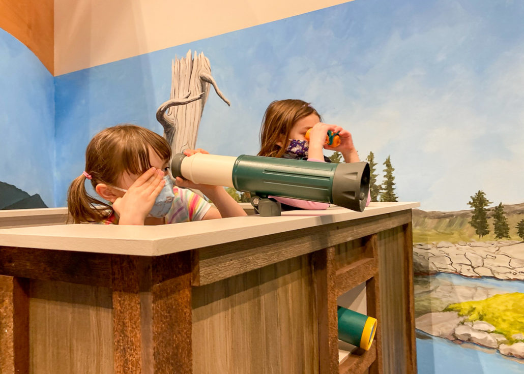 Two children using telescopes