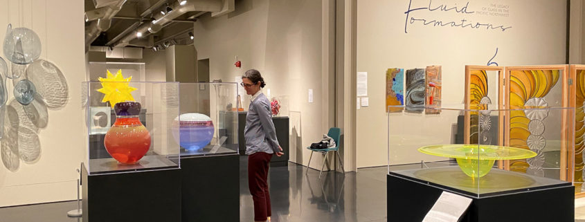 Woman in a museum gallery looking at glass art