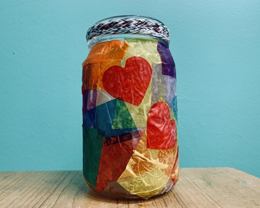 A glass jar with colorful paper decoupage